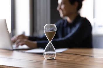 Chief time officer  sitting on desk with hourglass 